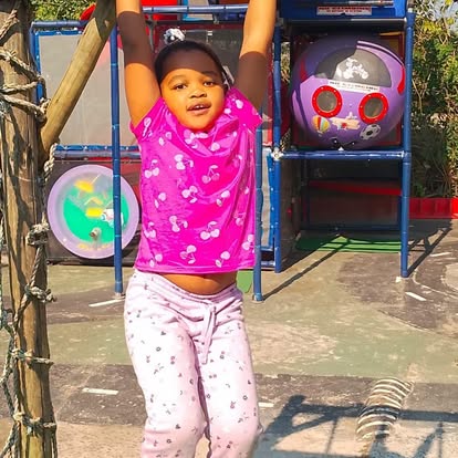 Child hanging from a rope climbing structure