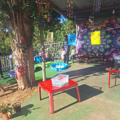 Outdoor sensory play area with tables and wind chimes