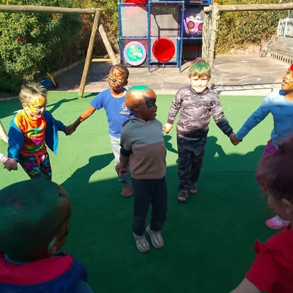 Children standing in a circle outdoors with face paint