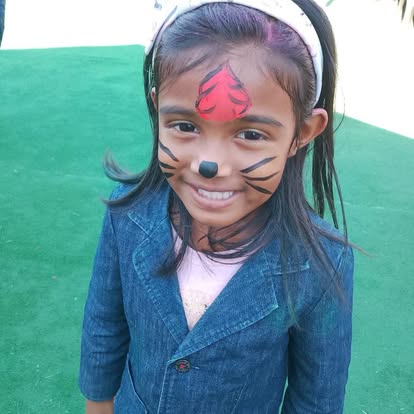 Child with tiger face paint smiling