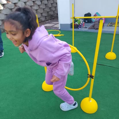 Child jumping through an agility hoop outdoors